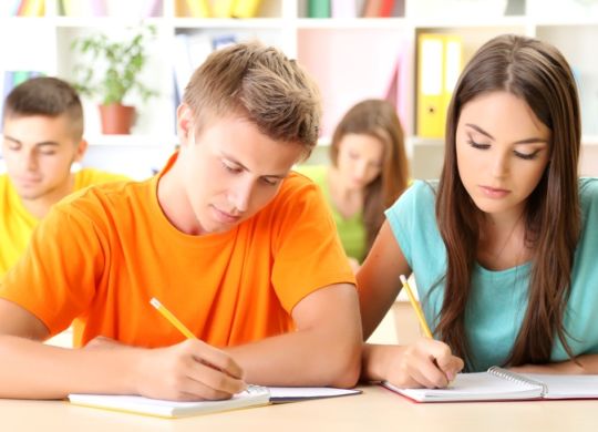 Group of young students sitting at the library